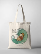 Christian tote bag collaboration between John Euclid and The Commandment Co featuring illustrated character resting inside an ocean wave with the phrase “Be still and know that He is God” from Psalm 46:10