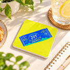Joy Energy Bar Christian coaster featuring Nehemiah 8:10 styled on a bright sunlit desk with a lemon drink and notebook.