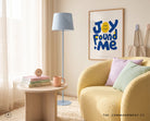 Joy Found Me poster displayed above a cosy yellow reading chair with pastel cushions