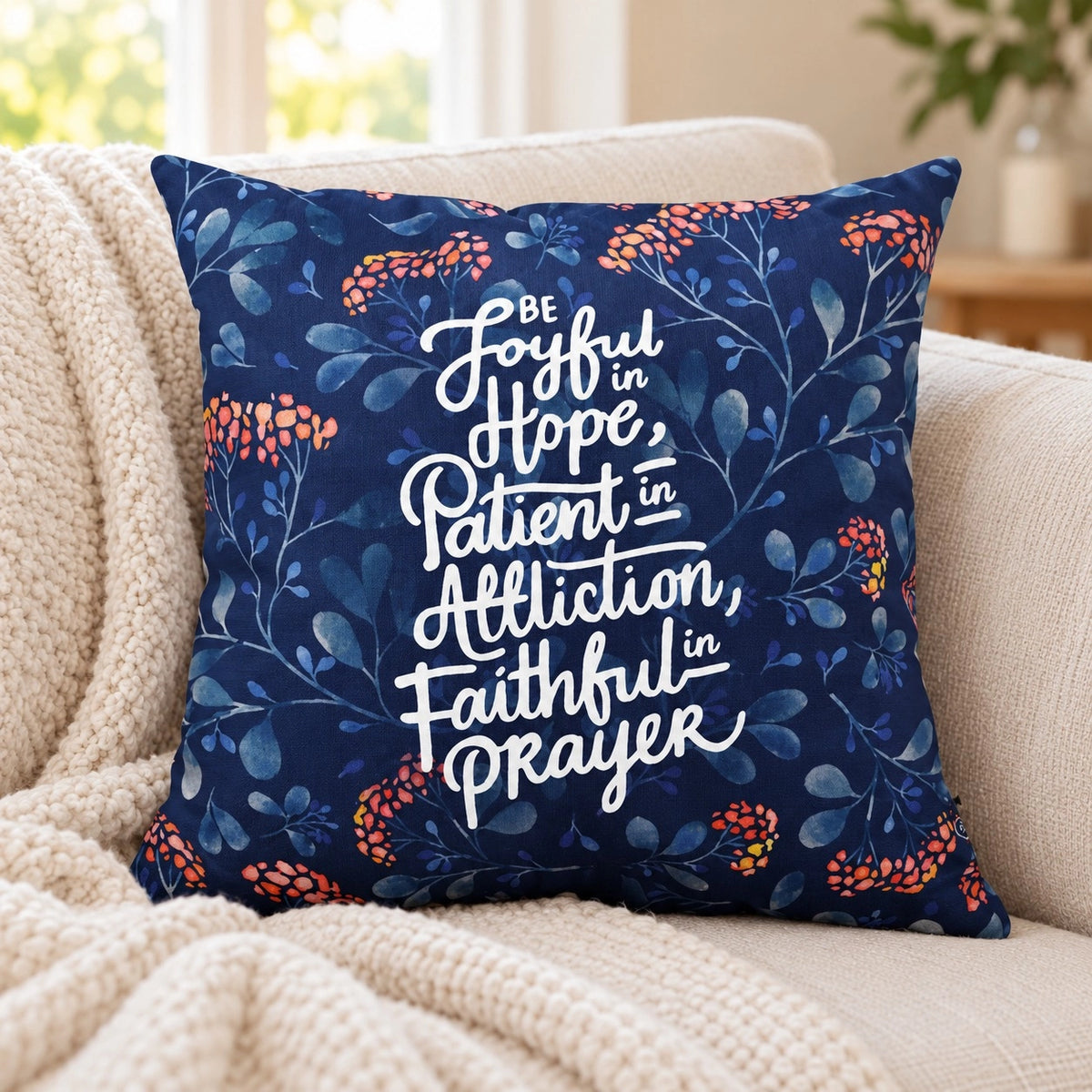 Joyful Patient Faithful Christian cushion cover featuring Romans 12:12 on a cream sofa.