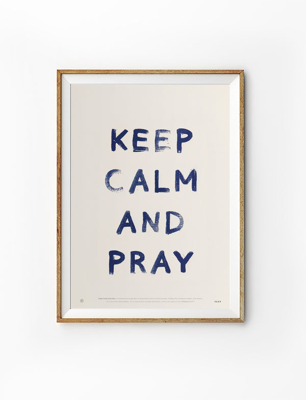 Keep Calm and Pray Christian poster with navy lettering displayed in a wooden frame against a white background