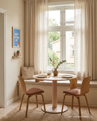 Keep Looking Up poster displayed beside a bright window in a warm minimalist dining nook