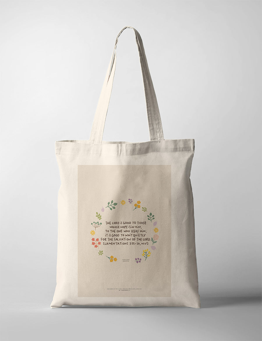 Christian tote bag featuring Lamentations 3:25-26 with floral artwork and a reminder to wait quietly for the Lord