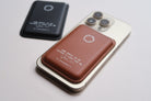 Lifestyle shot of brown Leather MagSafe Wallet attached to a smartphone, showcasing slim premium leather in everyday use