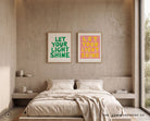 Green and pink Let Your Light Shine Christian posters displayed above a neutral bedroom