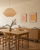 Pink and yellow Let Your Light Shine Christian poster displayed with a coral poster in a warm dining room