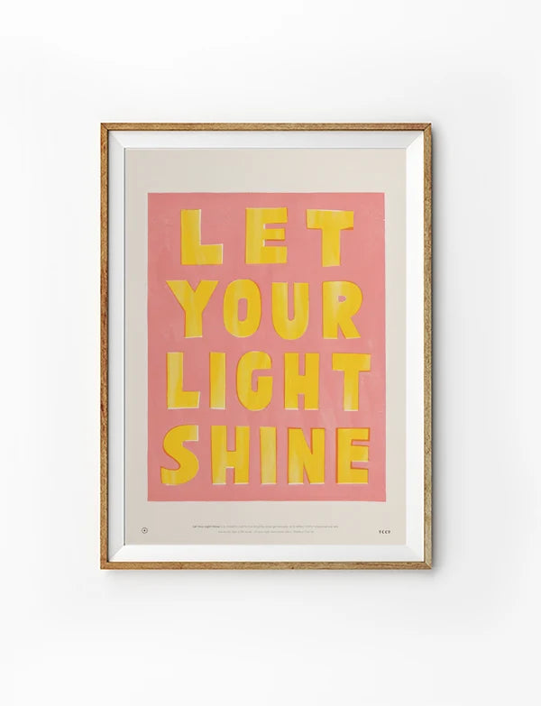 Let Your Light Shine Christian poster with yellow lettering on a pink background displayed in a wooden frame