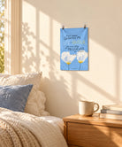 Life and Favor blue wall tapestry displayed above a cosy bedside table in warm natural light