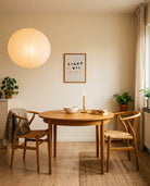 Light Always Wins Scripture poster displayed above a warm wooden dining table