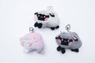 Three faith-inspired Lil Sheepies plush keychains in White Cumulus, Pink Hana, and Stormy Gray are displayed on a white background. Each soft, fluffy sheep represents a reminder of the Good Shepherd’s love, featuring a Bible verse charm, a retractable string for easy card access, and a secure keychain clip. Perfect as a Christian gift or daily faith companion.