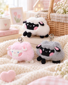 Lil Sheepies plushie keychains in white, pink and grey styled in a soft pastel lifestyle setting.