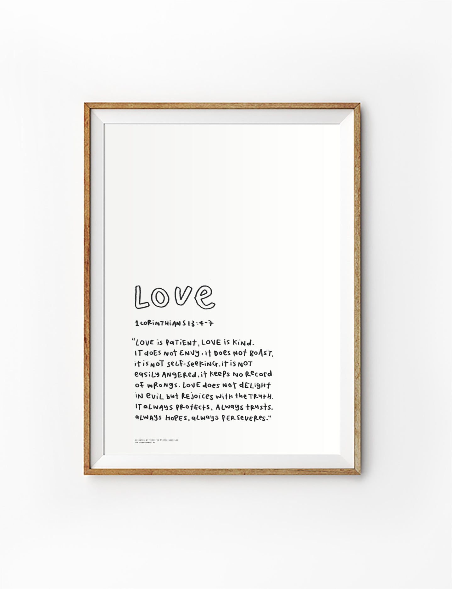 Love Bible verse poster featuring 1 Corinthians 13:4-7 in a simple handwritten style, displayed in a framed wall art mockup.