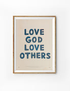 Framed Love God Love Others Christian poster with dark blue hand-drawn lettering and peach accents