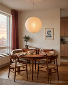 Framed Love God Love Others poster displayed beside a wooden dining table in a warmly lit home