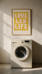 Love Led Life Christian wall art above a washing machine in warm natural light