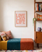 Love Led Life Christian poster displayed above a colourful bench beside a wooden bookshelf