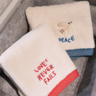 Love Never Fails Christian cotton towel with embroidered wording.