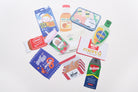 Flatlay of the Love Supermarket card set featuring 10 uniquely shaped Christian postcards inspired by food and household items.
