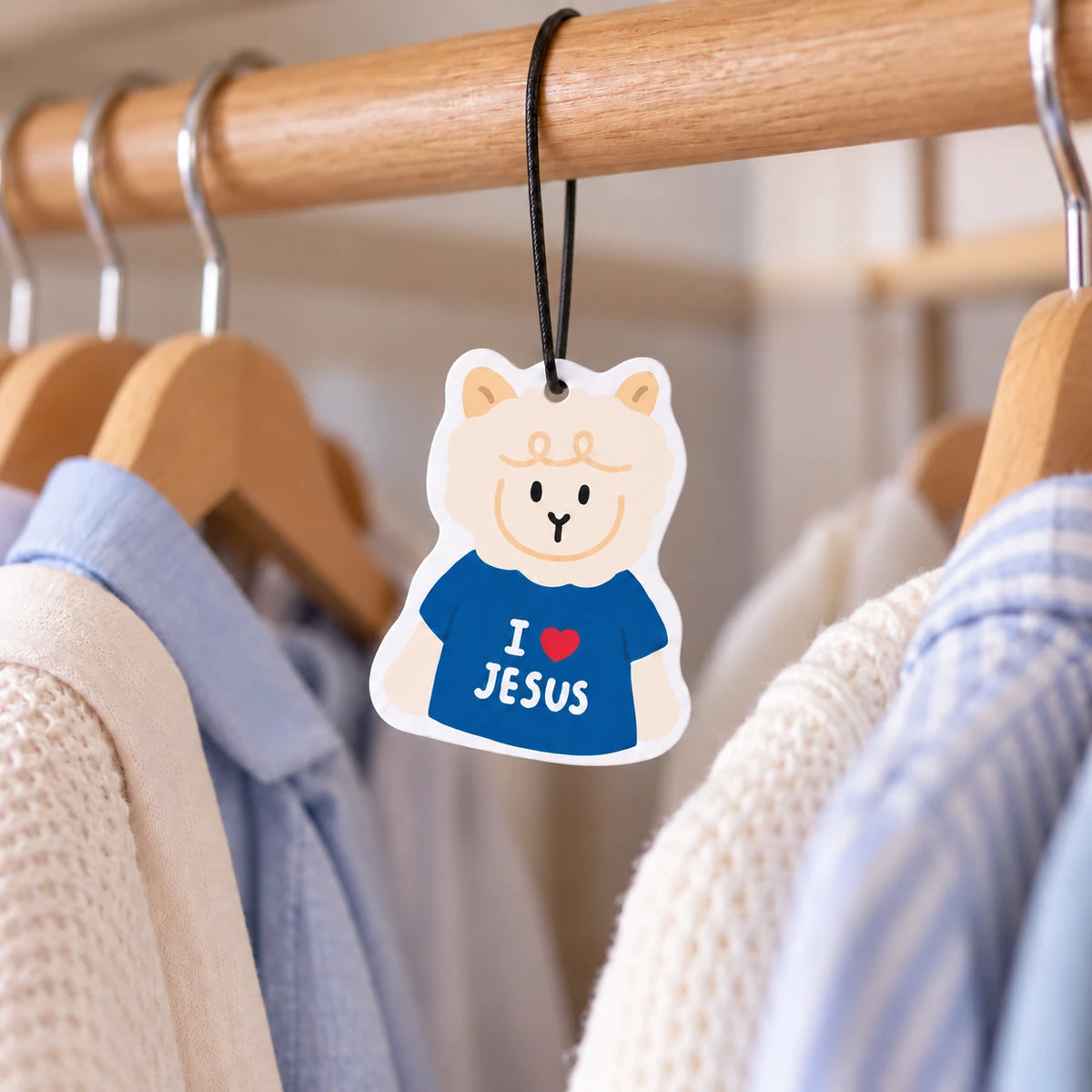 Love the Lamb sheep illustrated scent tag hanging from a wardrobe rail between clothes