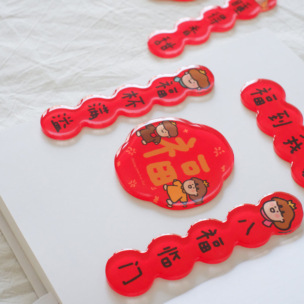 Chinese New Year couplet magnets with red festive decorations and adorable character designs placed on a white surface