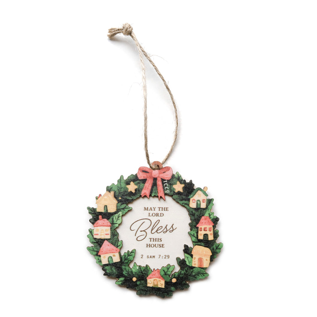 Beautiful Christmas ornament featuring a wreath decorated with miniature houses and a red bow, inscribed with 'May the Lord Bless This House' from 2 Samuel 7:29, perfect for holiday home decor or faith-inspired gifts.