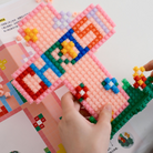 DIY micro-brick Christian cross building set with “CHRIST” lettering and colorful flowers, perfect for faith-inspired home decor and gifts