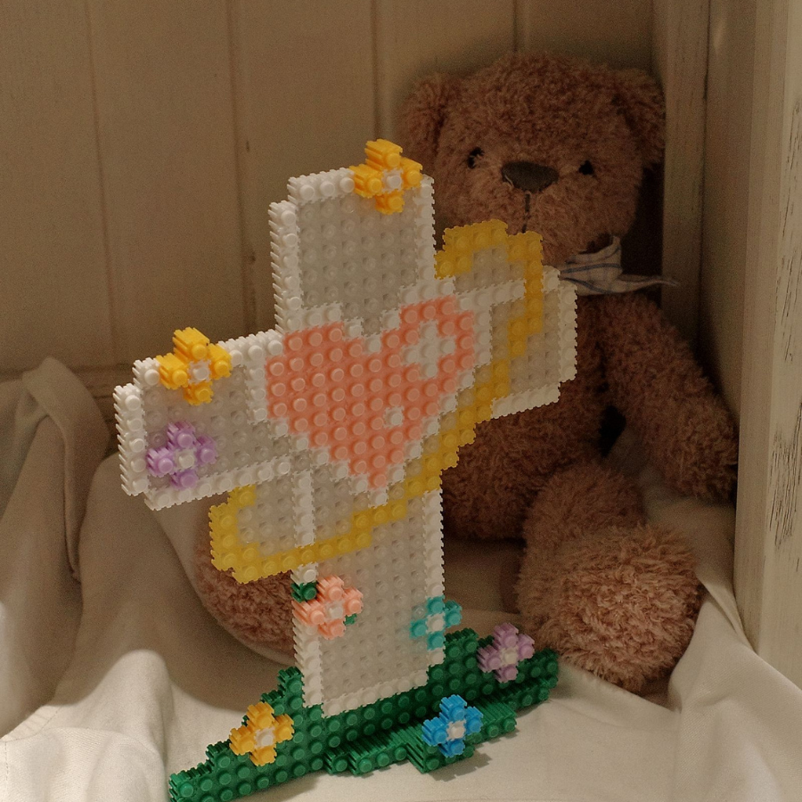  Micro building set cross with a heart and floral accents, symbolizing hope and light, displayed beside a teddy bear for a touch of simple happiness and encouragement.