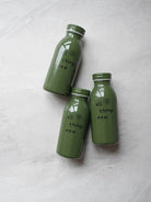 Three green milk-bottle-shaped stainless steel tumblers with the inspirational message 'all things new' on the front, reflecting a modern Christian gift.