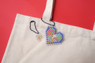 Mosaic heart and cross acrylic keychains attached to a tote bag, from The Commandment Co, Singapore.