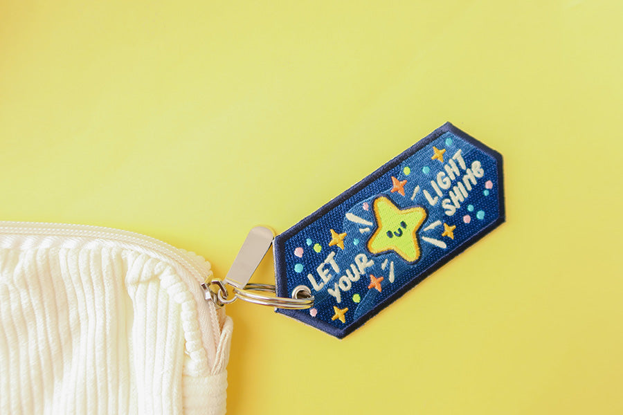 Cute keychain with embroidered stars and motivational text.