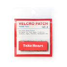Red Velcro tag with white text 'Take Heart,' an inspirational embroidered patch for faith-based apparel and accessories.