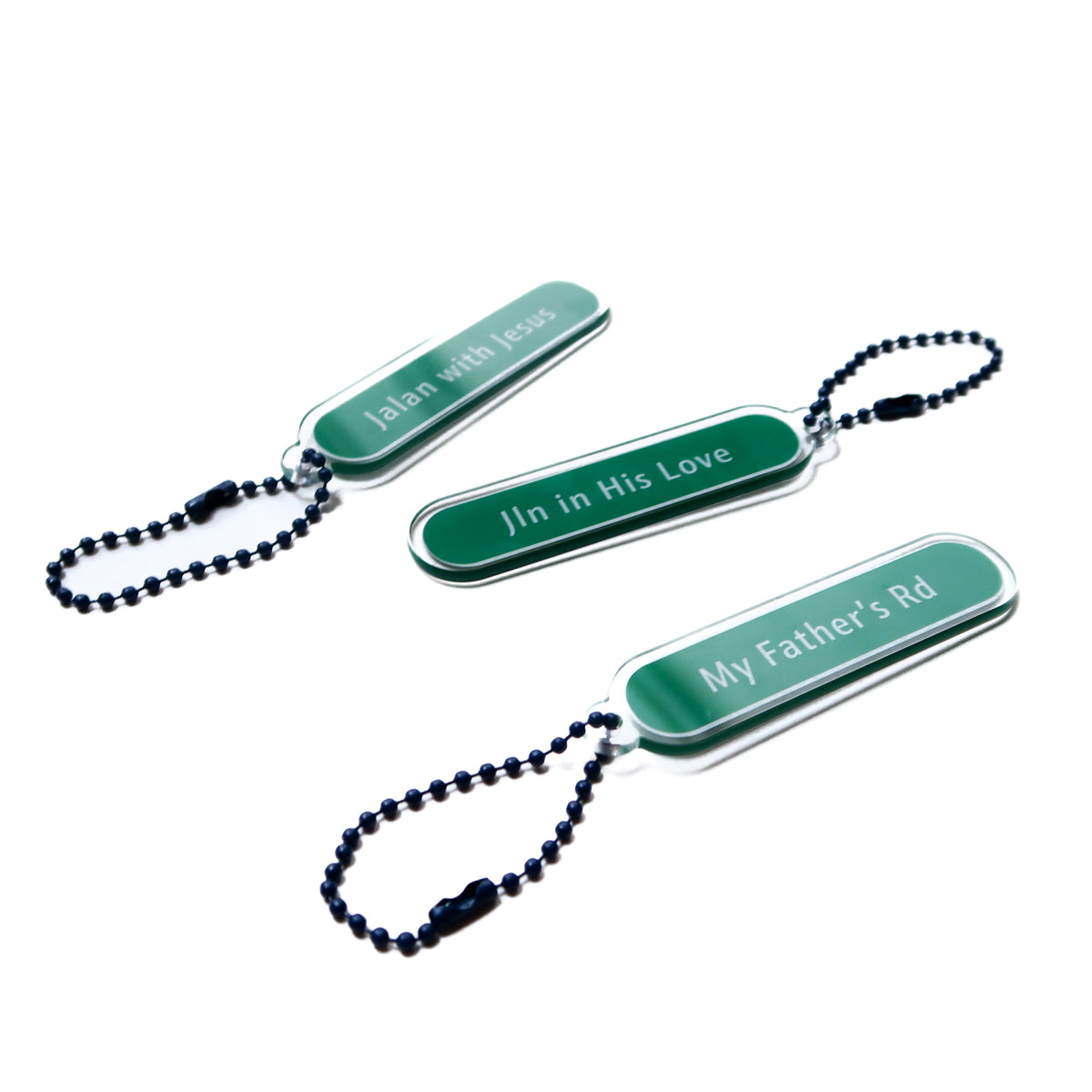My Father’s Road Christian acrylic keychain shown with Singapore-inspired keychain designs.