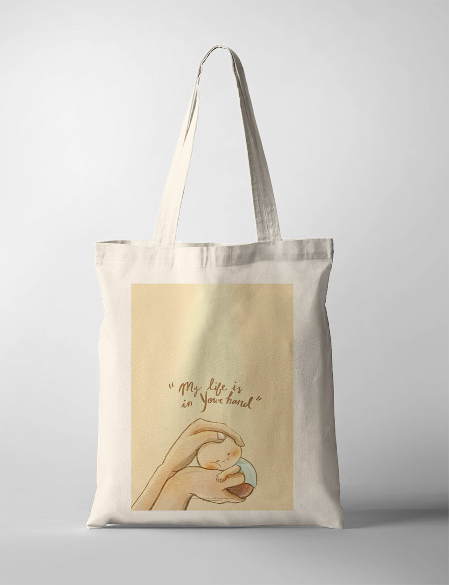 Christian tote bag featuring hands gently holding a small child with the phrase “My life is in Your hand,” inspired by Psalm 31:15