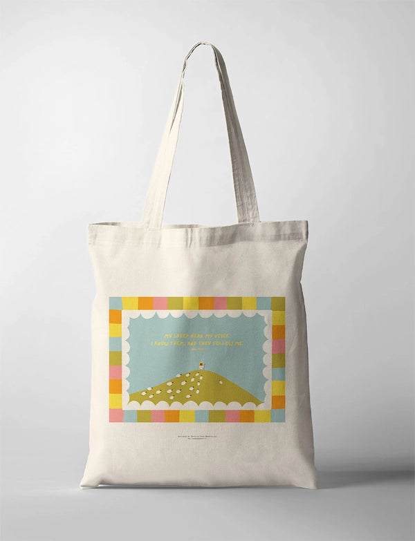 My Sheep Hear My Voice CollabPlus+ tote bag featuring Jesus guiding sheep on a hillside, inspired by John 10:27 and designed by @nartellac