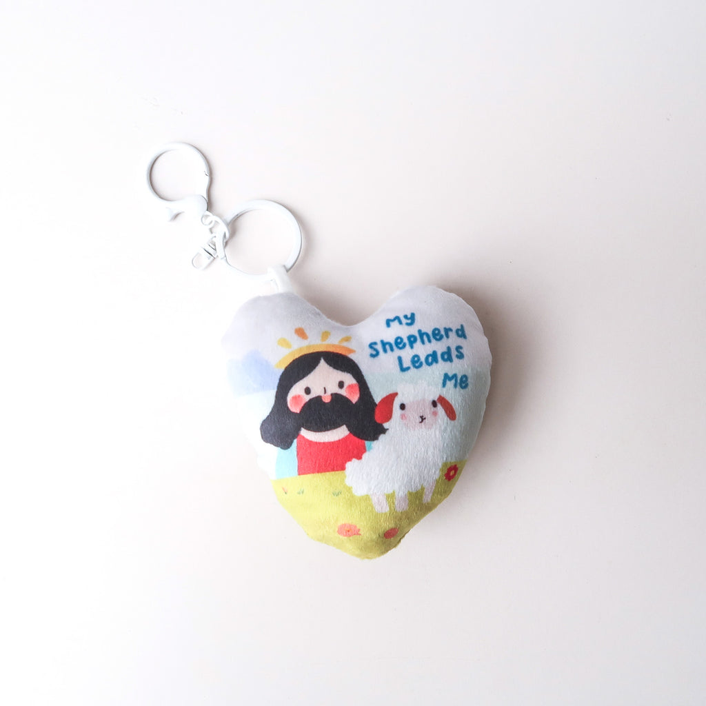 Heart-shaped plush keychain featuring Jesus with a sheep and the text 'My Shepherd Leads Me,' symbolizing faith and guidance.