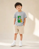 Young child wearing the grey Mylo Mine dinosaur drink packet kids’ T-shirt