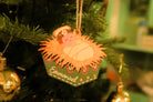 Emmanuel baby Jesus Christmas bauble hanging on a decorated Christmas tree