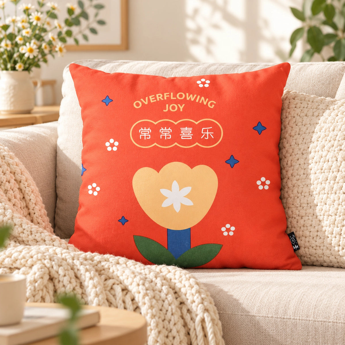 Overflowing Joy red Christian cushion cover styled on a sunlit neutral sofa.