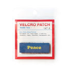 Blue Velcro tag with yellow text 'Peace,' an inspirational Christian embroidered patch for apparel and accessories