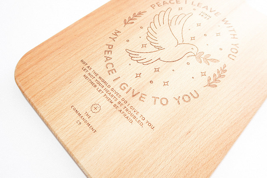 Solid beech Christian cutting board with rounded handle and Peace I Leave With You design.