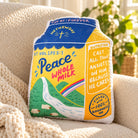 Peace Whole Milk plush toy styled on a cosy sofa in a sunlit living room