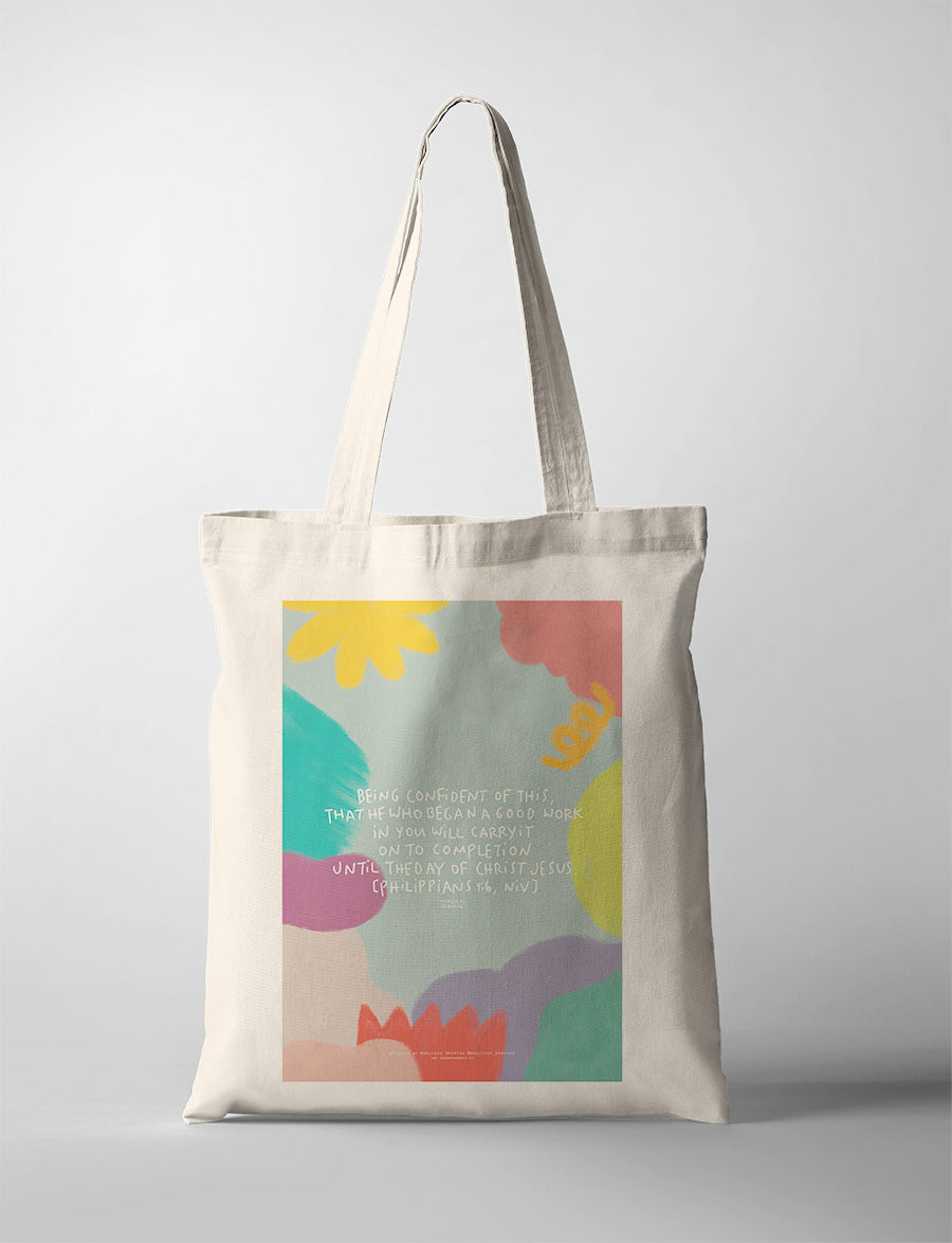 Christian tote bag featuring Philippians 1:6 with colourful artwork about God completing the good work He began