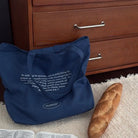 Navy Christian canvas tote bag featuring Philippians 4:6–7, styled beside an open Bible and bread in a cosy everyday setting