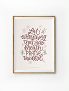 A faith-based poster featuring the Bible verse 'Let everything that has breath praise the Lord' in elegant handwritten typography. Surrounding the text are soft pastel-colored floral and leaf illustrations on a warm beige background. The Christian wall art is framed in a simple wooden frame, making it a meaningful piece for home decor, a prayer corner, or a worship space.