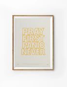 Pray First Panic Never outline Christian poster with hand-drawn yellow lettering on a soft neutral background