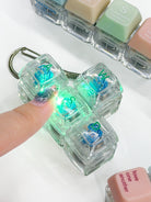Press-on light-up Christian keycap keychains glowing when pressed, shown together on a bright tabletop