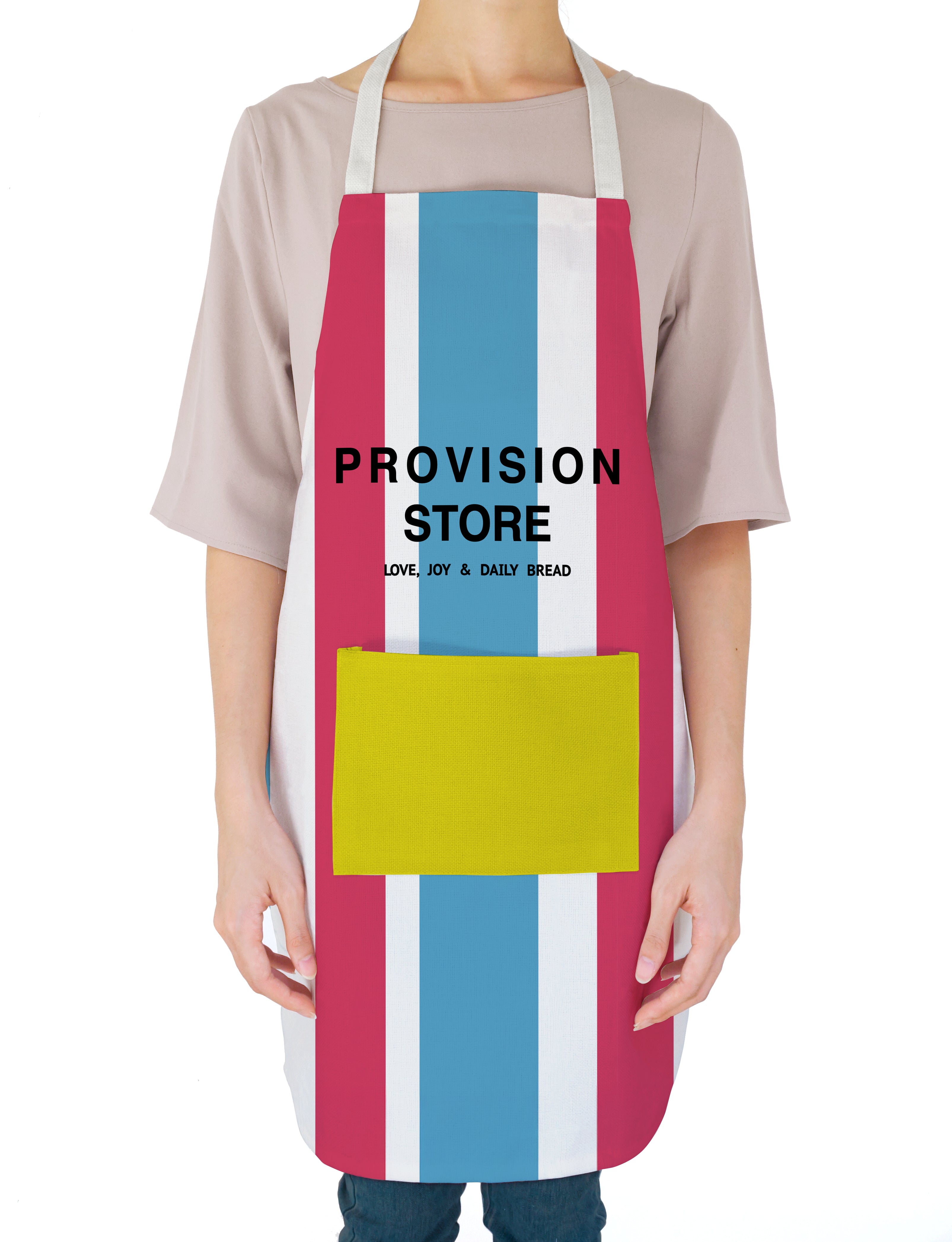  A person wearing a colorful "Provision Store" apron with bold red, blue, and white stripes and a yellow pocket, featuring the uplifting message "Love, Joy & Daily Bread," reflecting simple happiness and daily provision.