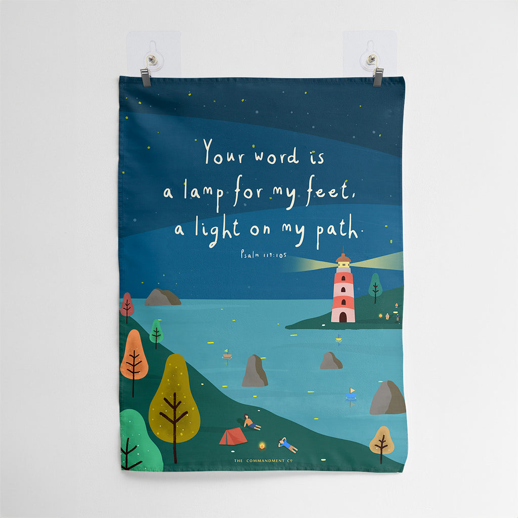 Christian wall art with Psalm 119:105, 'Your word is a lamp for my feet, a light on my path,' featuring a lighthouse illuminating a serene coastal scene under a starry night sky.