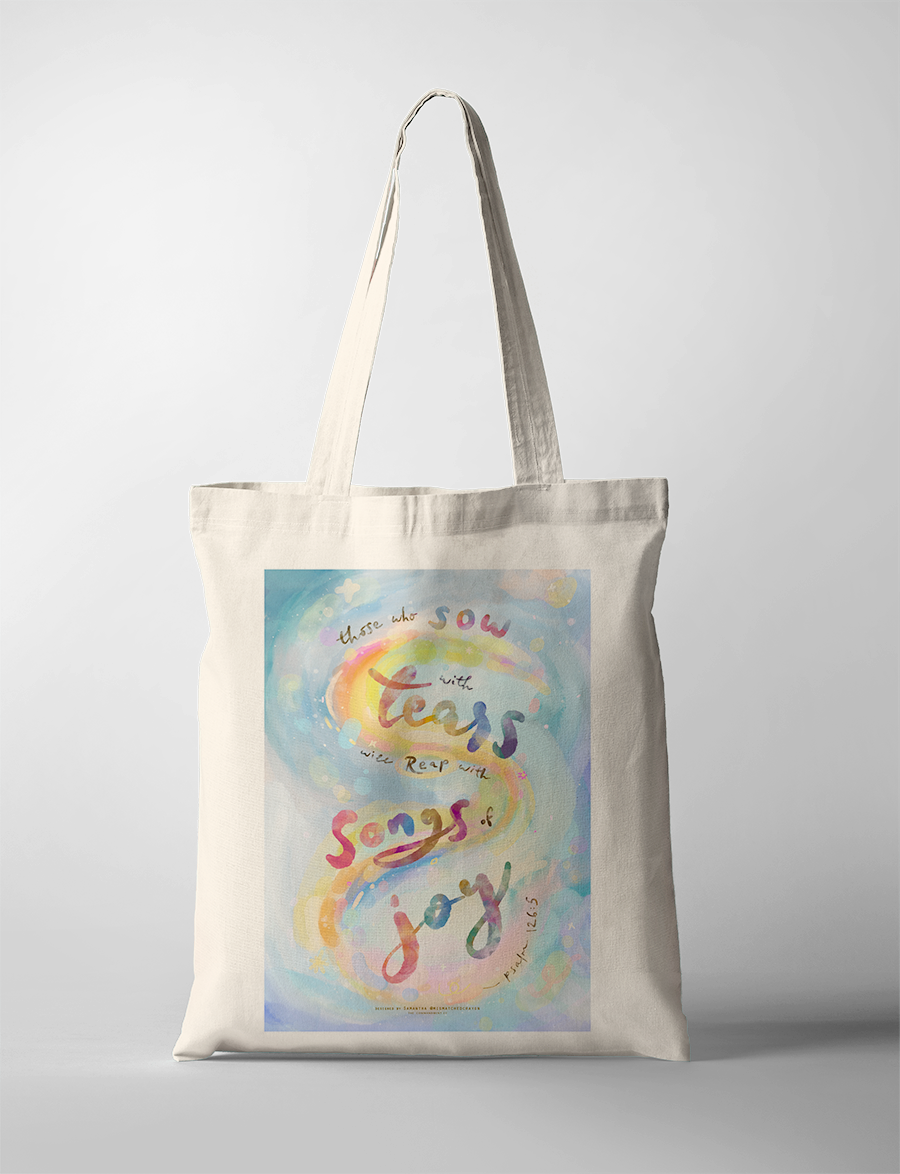 Inspirational Christian tote bag with Psalm 126:5 “Those who plant in tears will harvest with shouts of joy,” watercolor lettering in pastel rainbow tones.