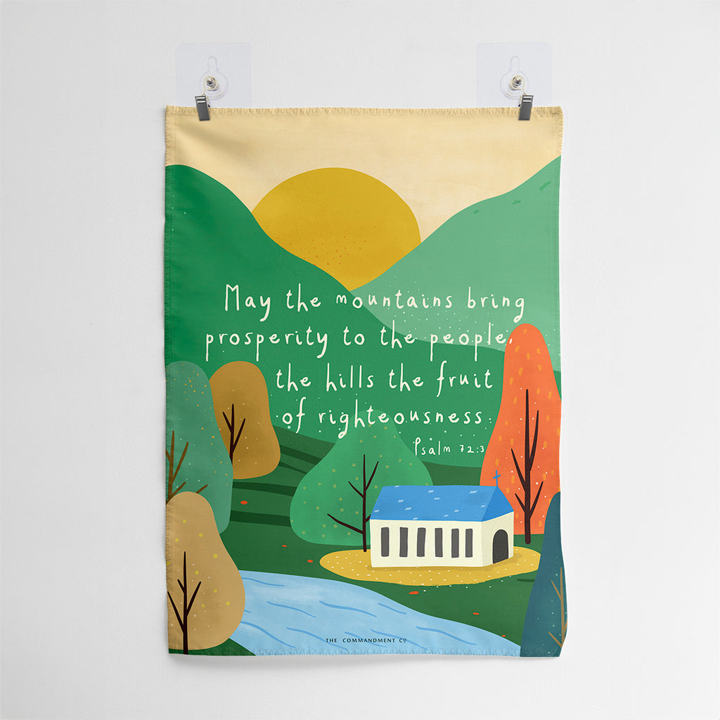 Christian wall art with Psalm 72:3, 'May the mountains bring prosperity to the people, the hills the fruit of righteousness,' featuring a peaceful illustration of a church, hills, and sunrise.